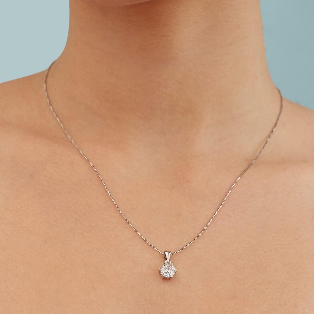 Diamond necklace on a person's neck against a light blue background