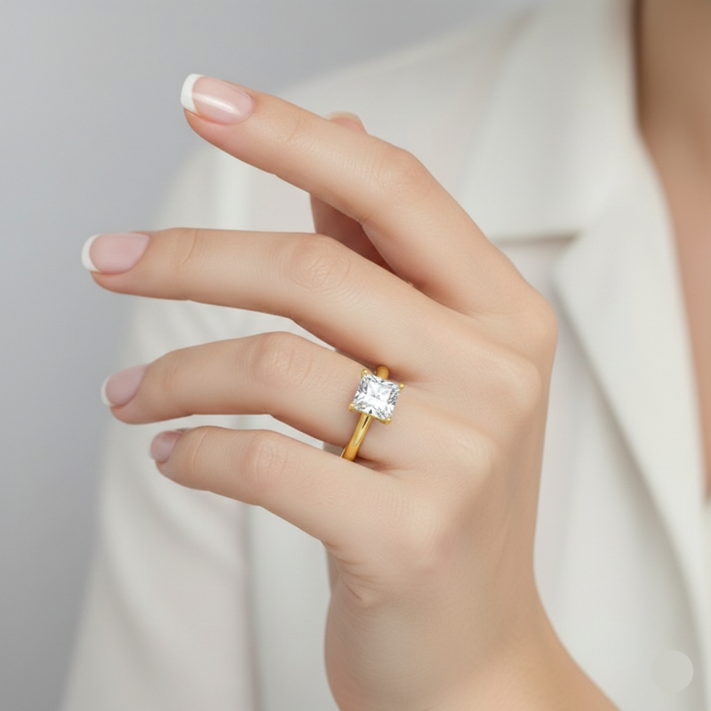 Gold ring with a diamond on a hand against a neutral background