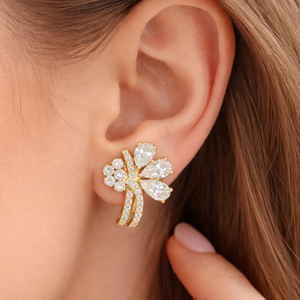 Close-up of a person wearing a gold and diamond earring.