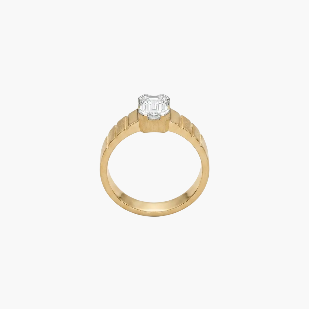 Gold ring with a diamond on a light gray background