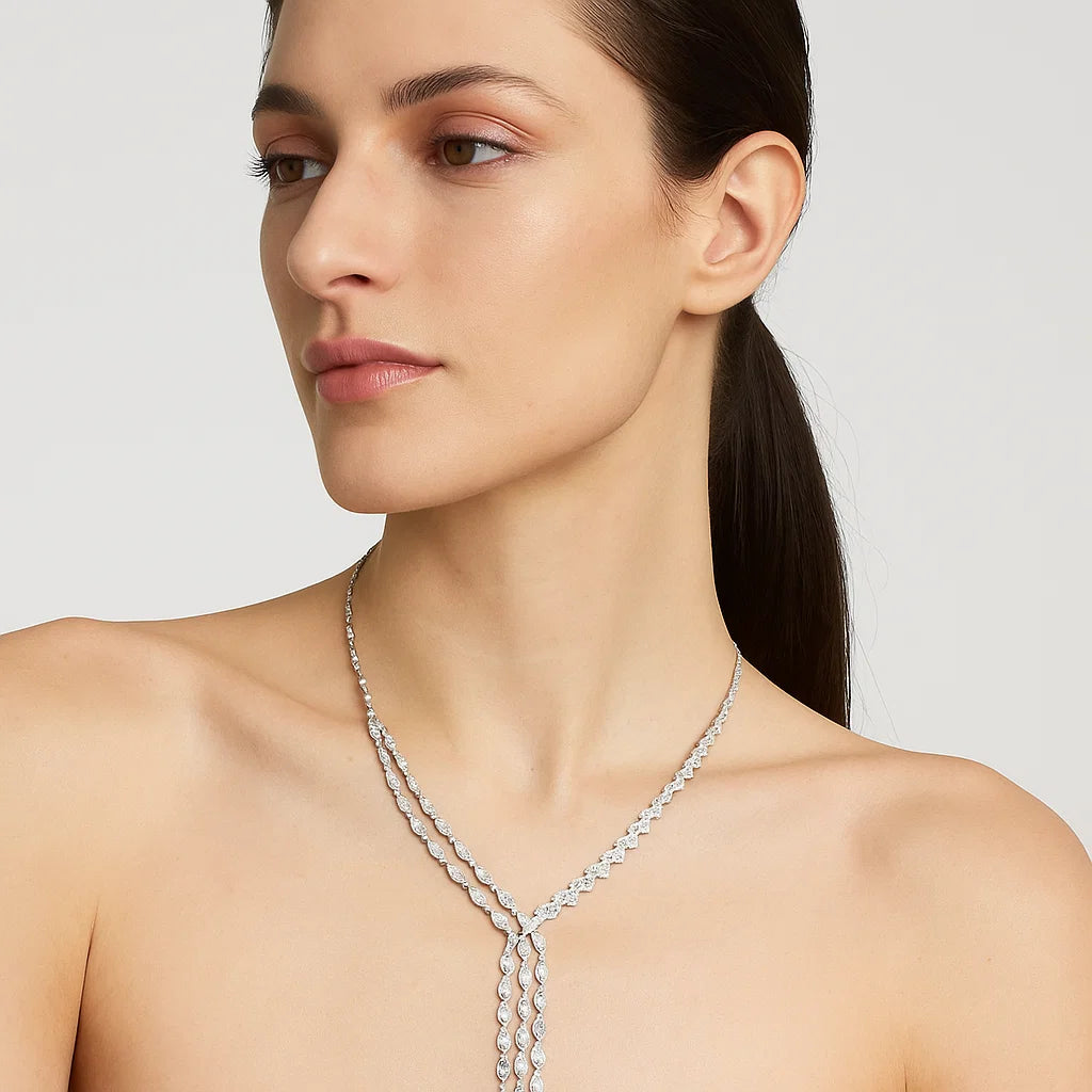 Woman wearing a silver necklace against a plain background