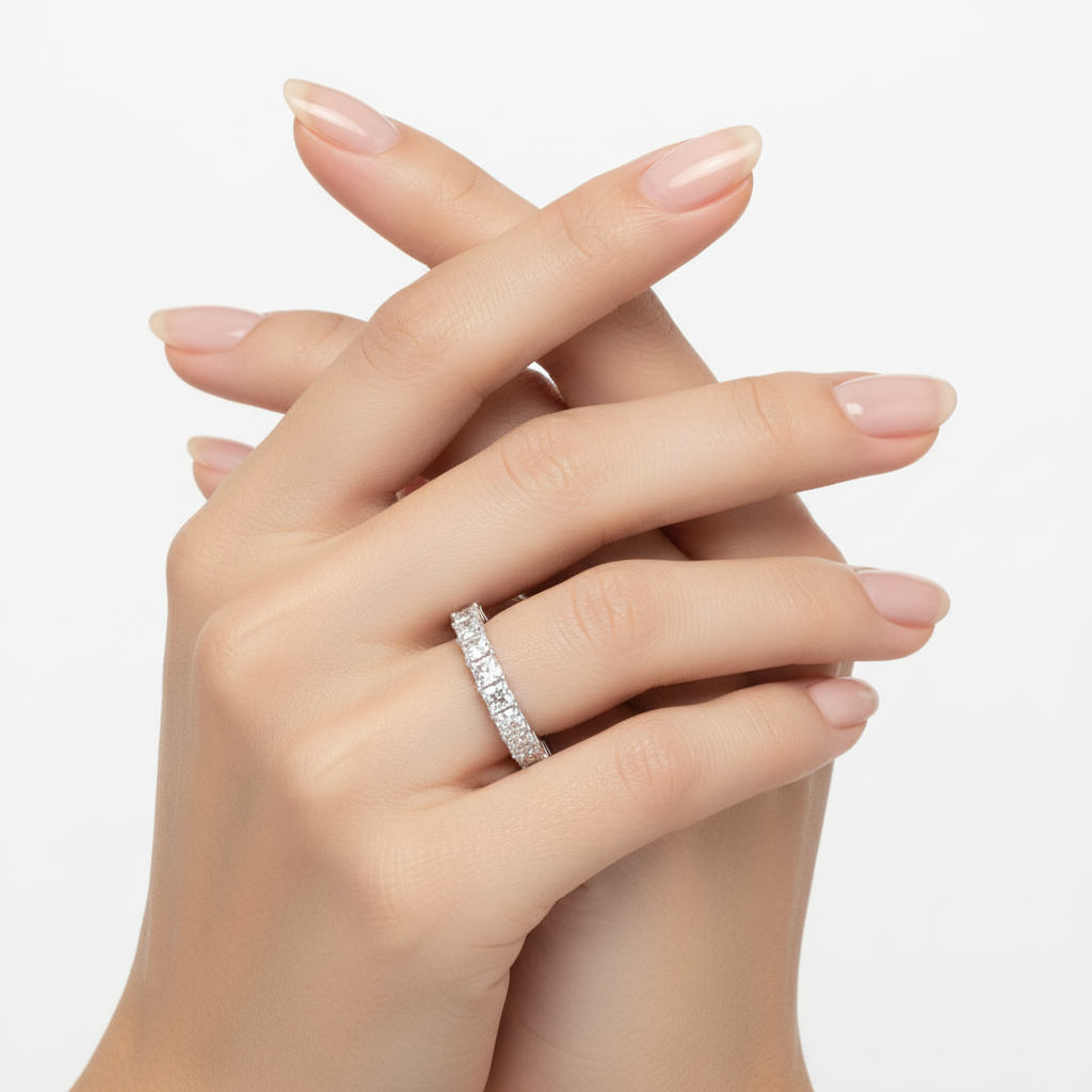 Female model wearing delicate white gold princess-cut diamond eternity band