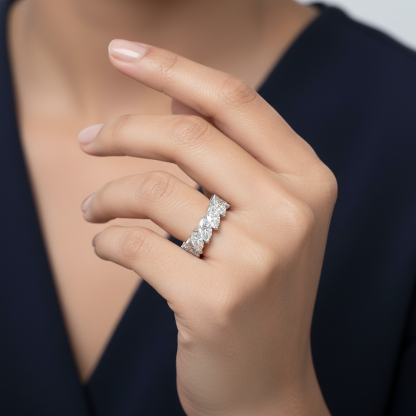 Generated image of a beautiful Indian female model wearing the white gold marquise-cut diamond full eternity band with continuous complete ring of large horizontally oriented marquise-cut diamonds in minimal two-claw white gold settings creating a spectacular wall-to-wall marquise diamond eternity band with beautiful undulating scalloped silhouette