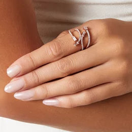 Close-up of a hand wearing two rings on a neutral background