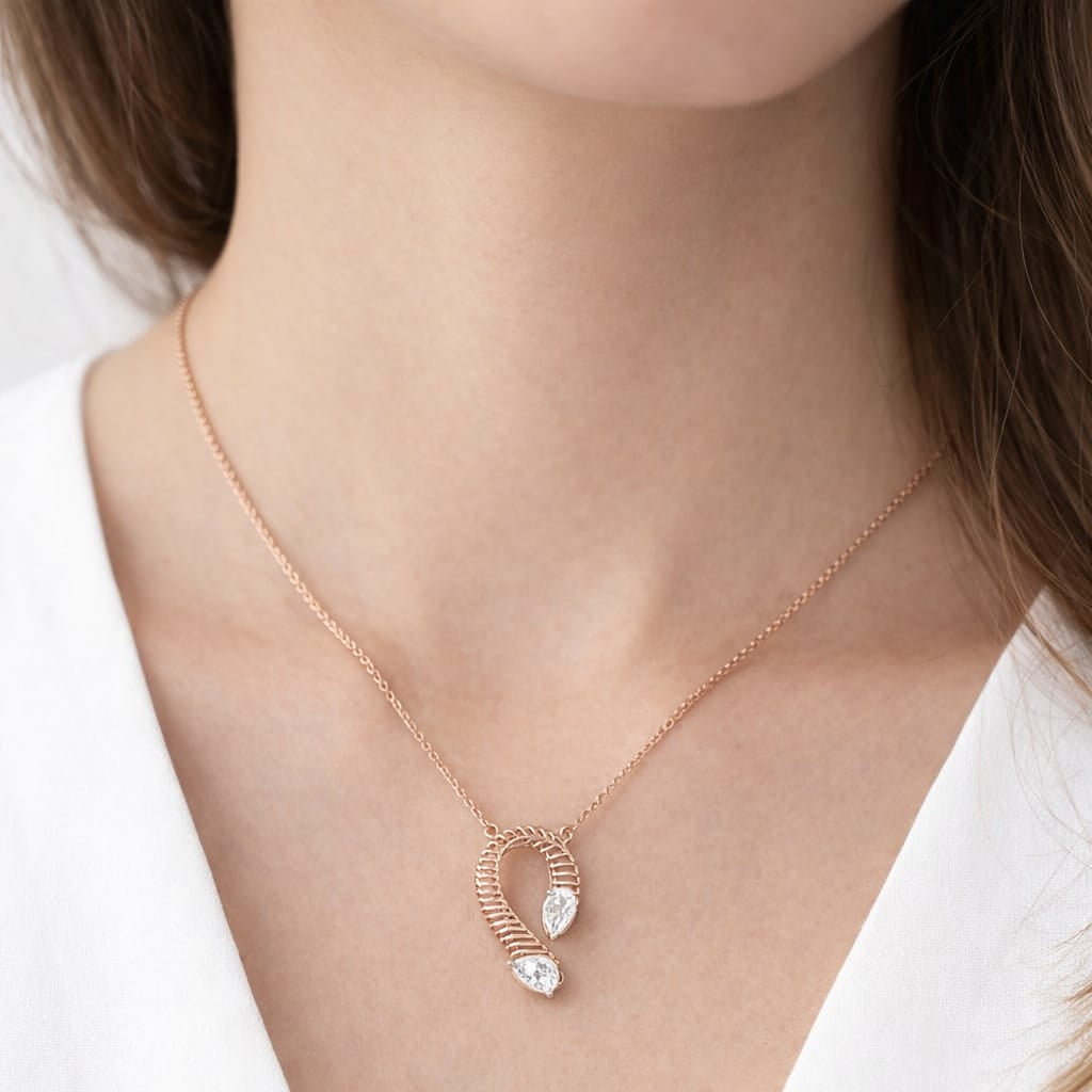 Rose gold necklace with heart-shaped pendant on a white background