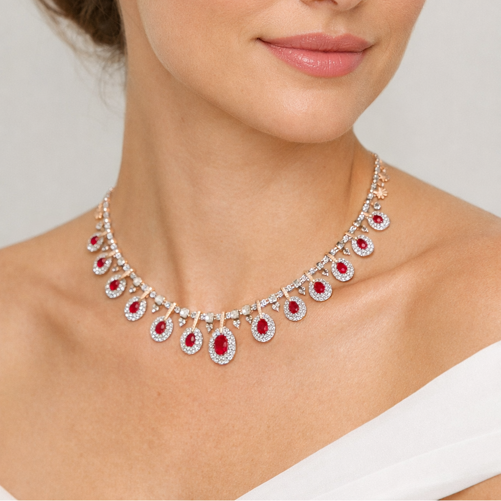Woman wearing a sparkling necklace with red stones on a plain background