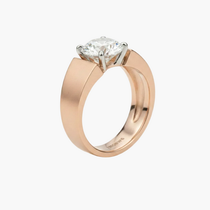 Rose gold ring with a diamond on a light gray background