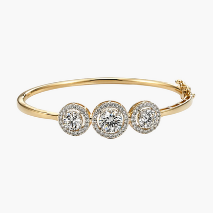 Gold bracelet with three diamond-like stones on a white background