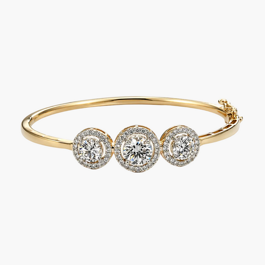Gold bracelet with three diamond-like stones on a white background