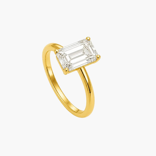 Gold ring with a rectangular diamond on a white background