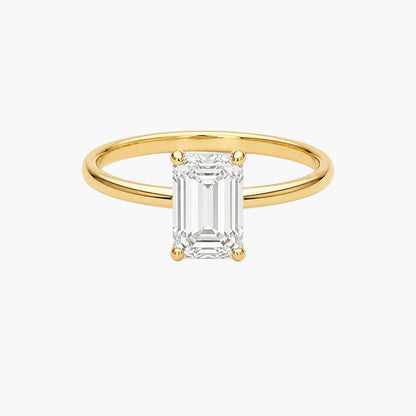 Gold ring with a rectangular diamond on a white background