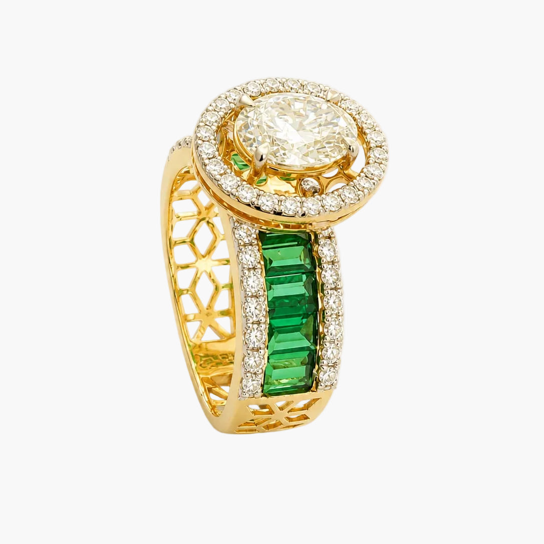 Gold ring with emerald and diamond accents on a white background