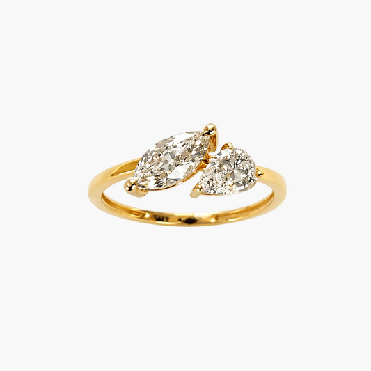 Gold ring with two pear-shaped diamonds on a white background