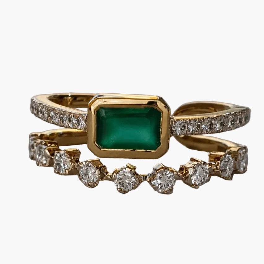 Gold ring with a green gemstone and diamond accents on a white background