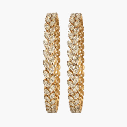 Pair of gold earrings with intricate design on a white background