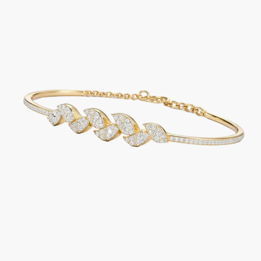 Gold bracelet with leaf-shaped design on a white background