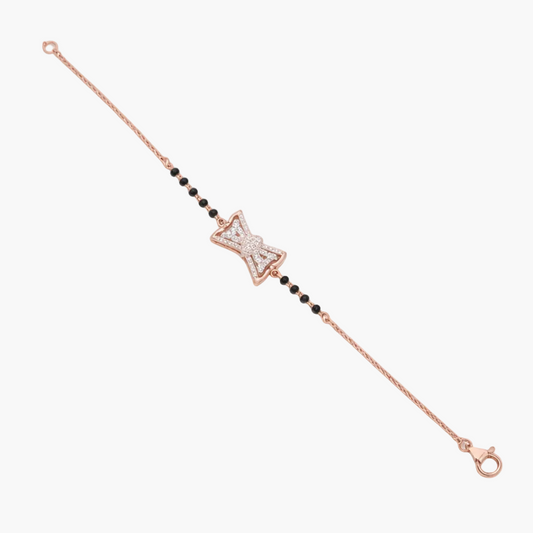Rose gold bracelet with star-shaped clasp and black beads on a white background