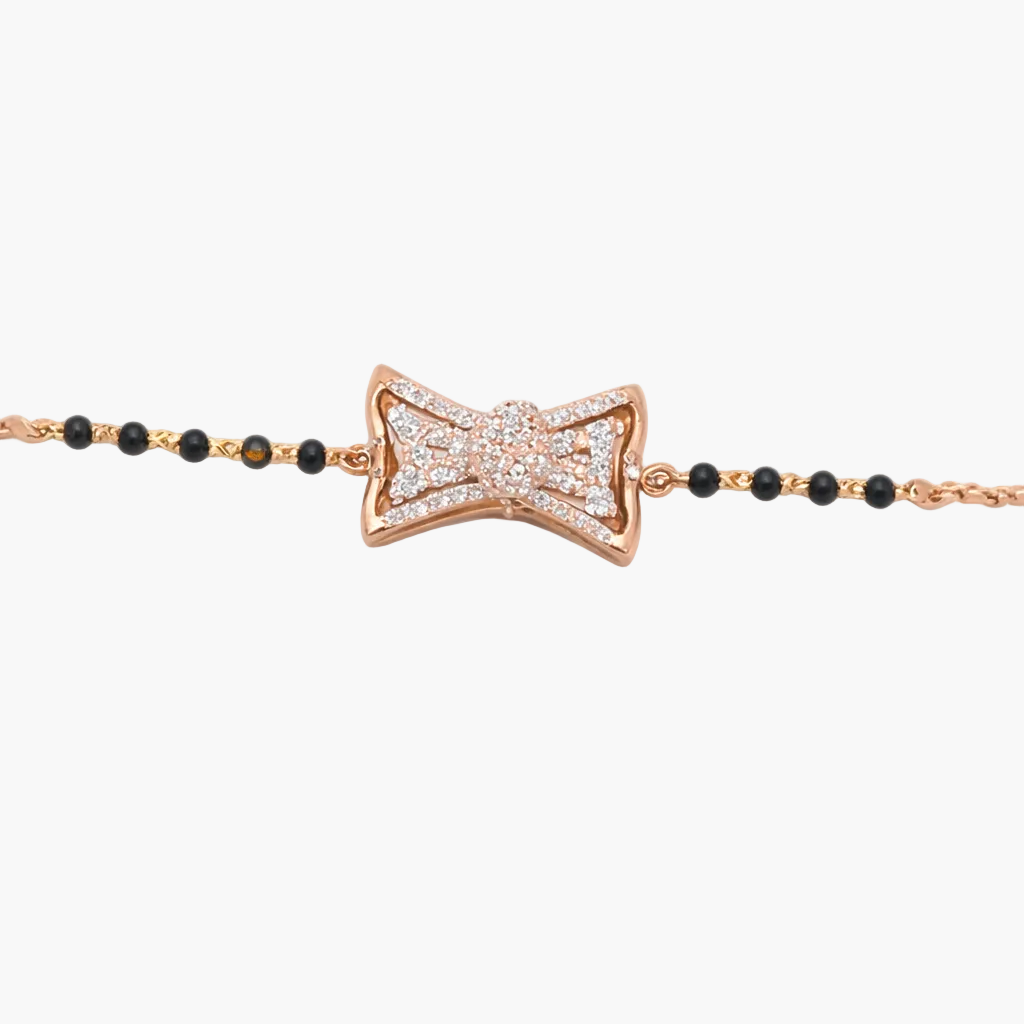 Rose gold bow-shaped bracelet with black beads on a white background