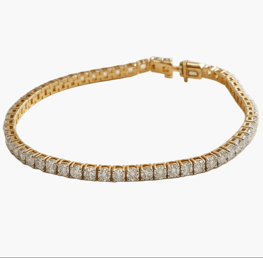 Gold bracelet with diamond accents on a white background
