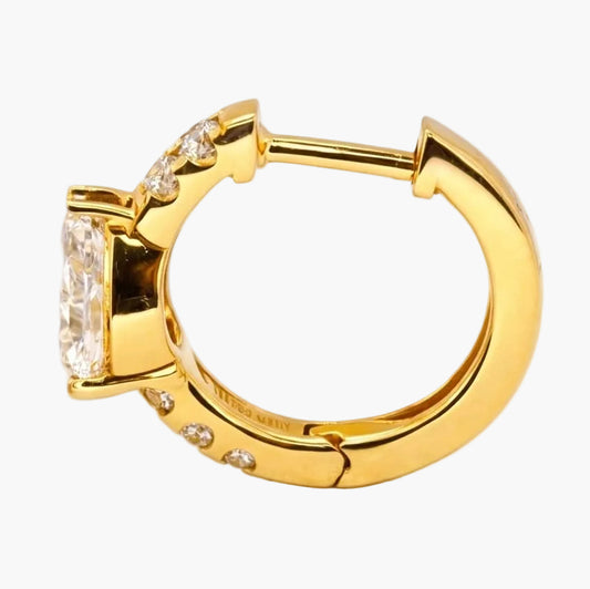 Gold hoop earring and teardrop-shaped stud earring on a white background