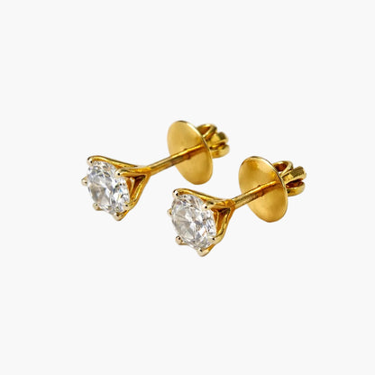 Gold stud earrings with clear gemstones on a white background