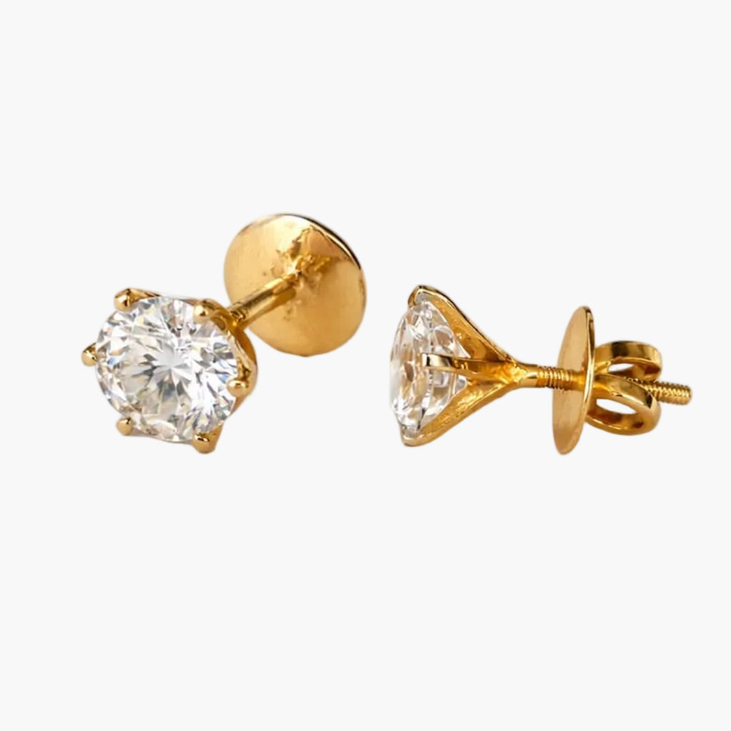 Pair of gold stud earrings with clear gemstones on a white background
