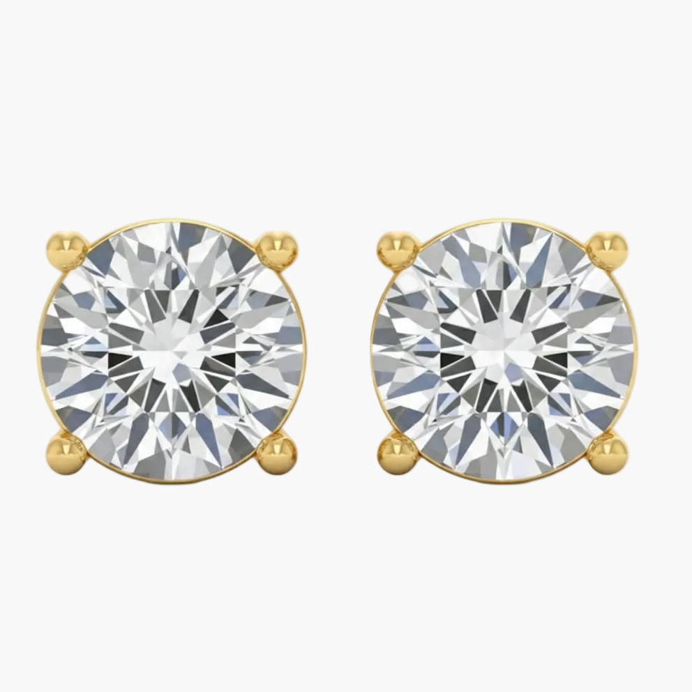 Gold earrings with large clear gemstones on a white background