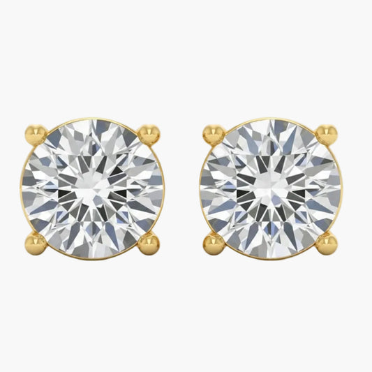 Gold earrings with large clear gemstones on a white background