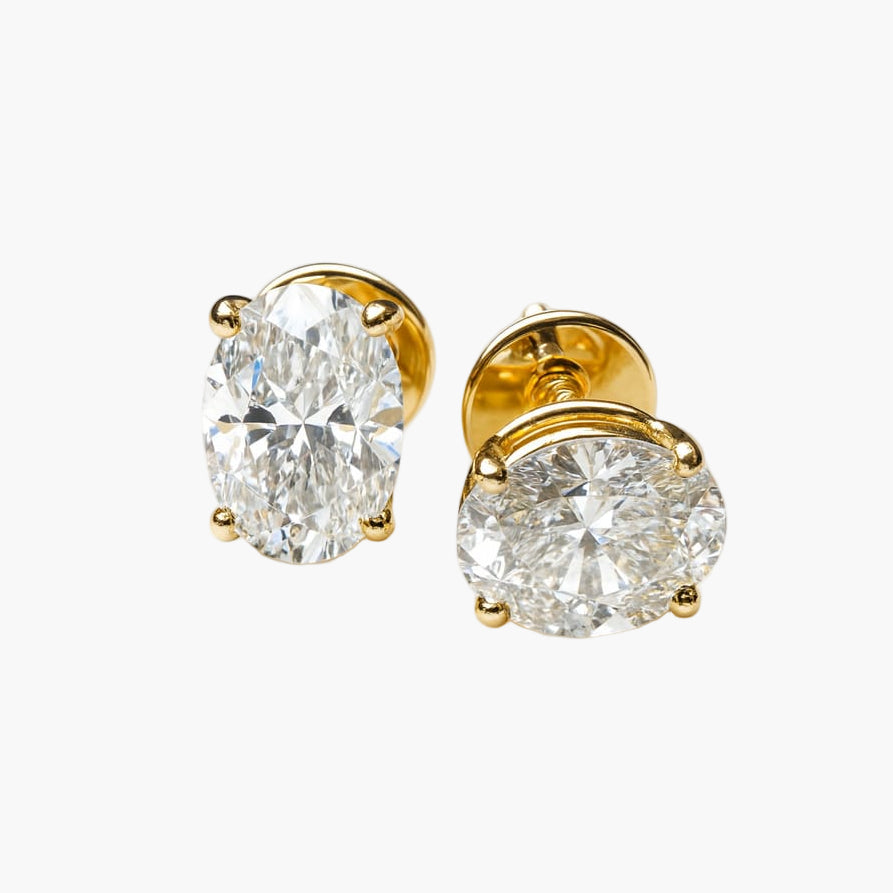 Gold earrings with large clear gemstones on a white background