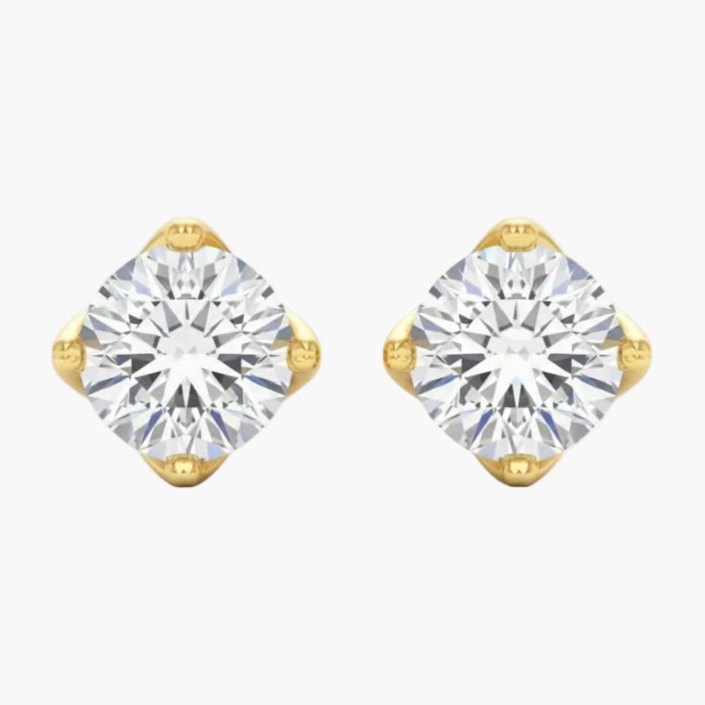 Gold earrings with clear gemstones on a white background