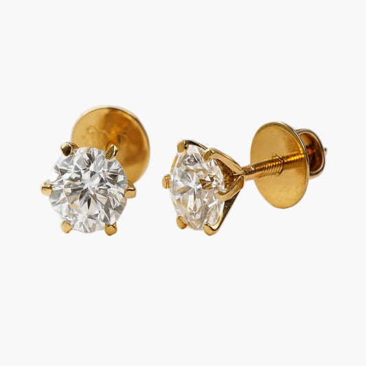 Gold earrings with clear gemstones on a white background