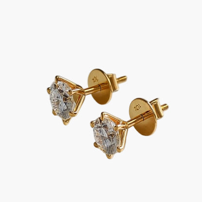 Gold earrings with clear gemstones on a white background