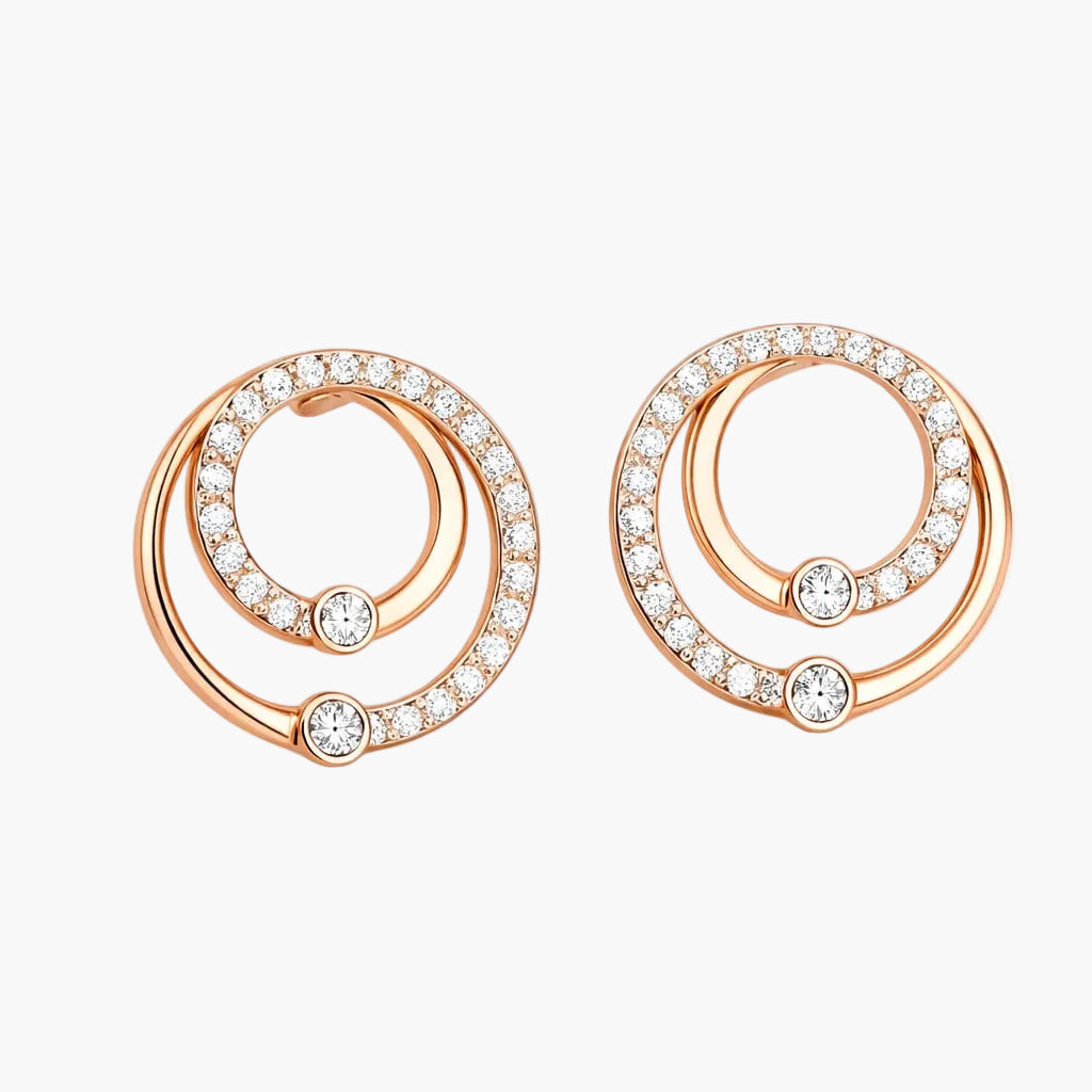 Rose gold earrings with circular design and embedded diamonds on a white background