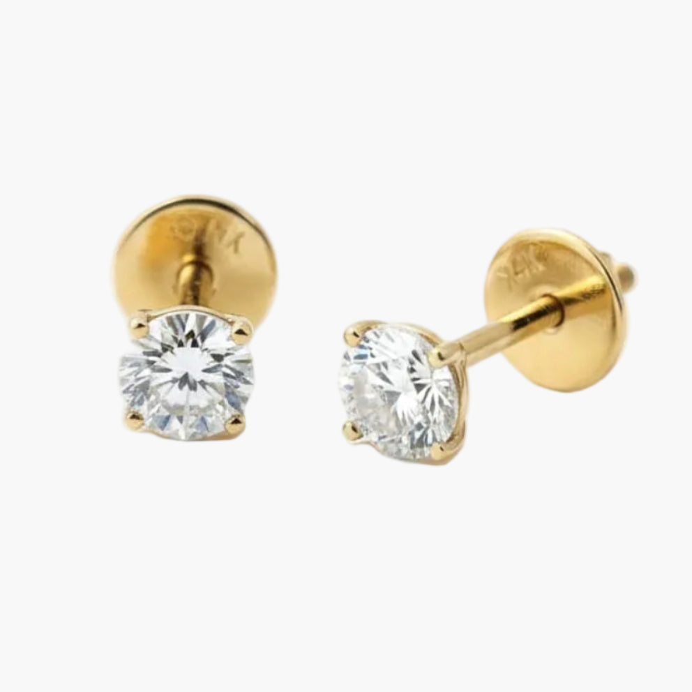Gold stud earrings with clear gemstones on a white background