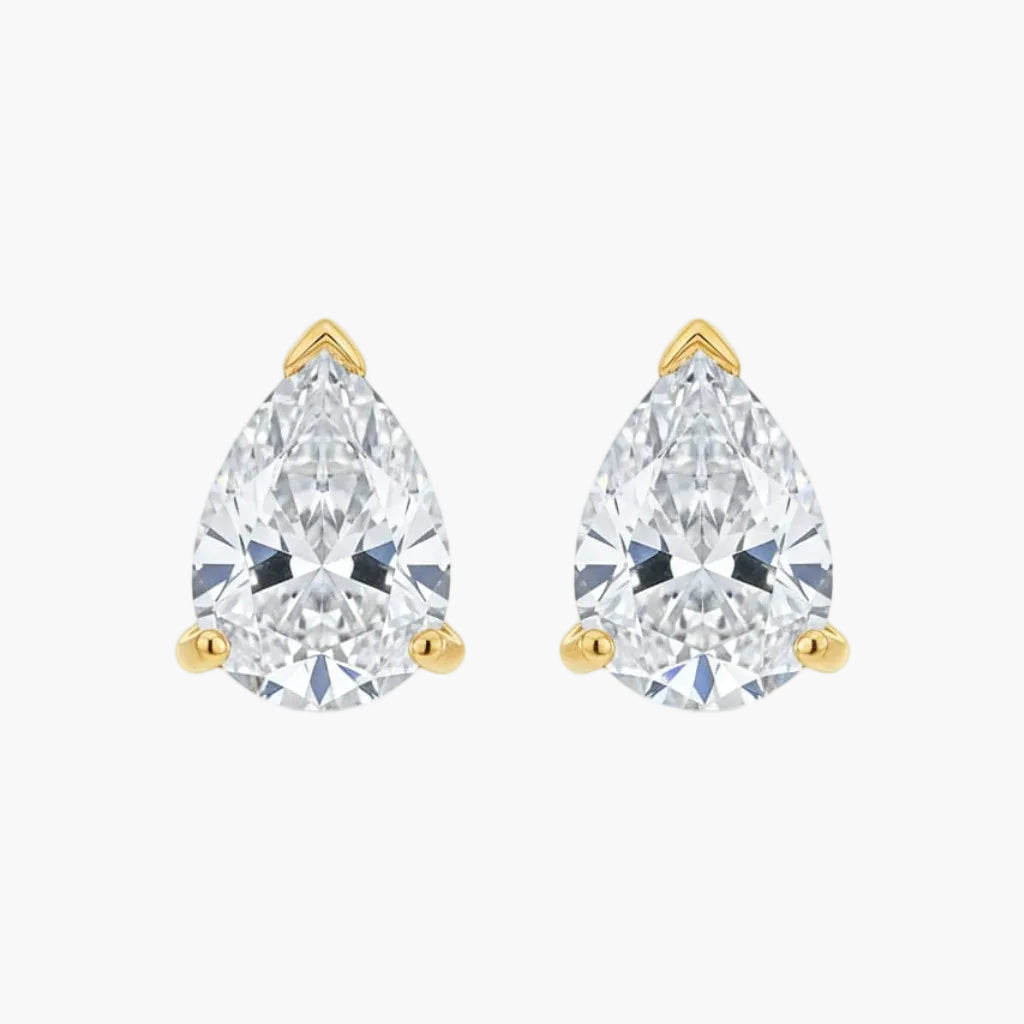 Pair of pear-shaped diamond stud earrings with gold settings on a white background