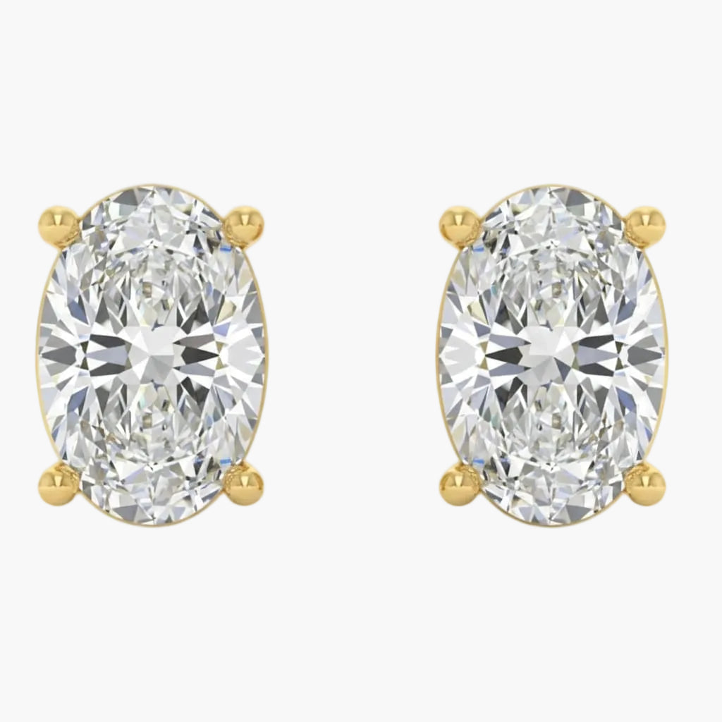 Gold earrings with large clear gemstones on a white background