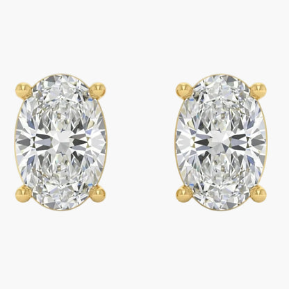Gold earrings with large clear gemstones on a white background