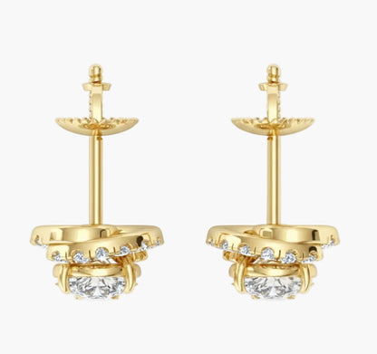 Gold earrings with clear gemstones on a white background