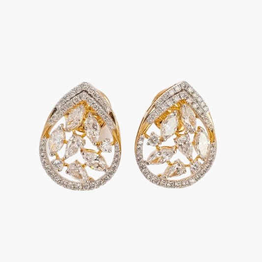 Gold and diamond earrings on a light gray background