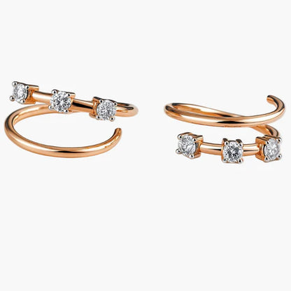Rose gold open hoop earrings with clear gemstones on a white background