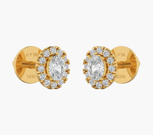Gold earrings with clear gemstones on a white background
