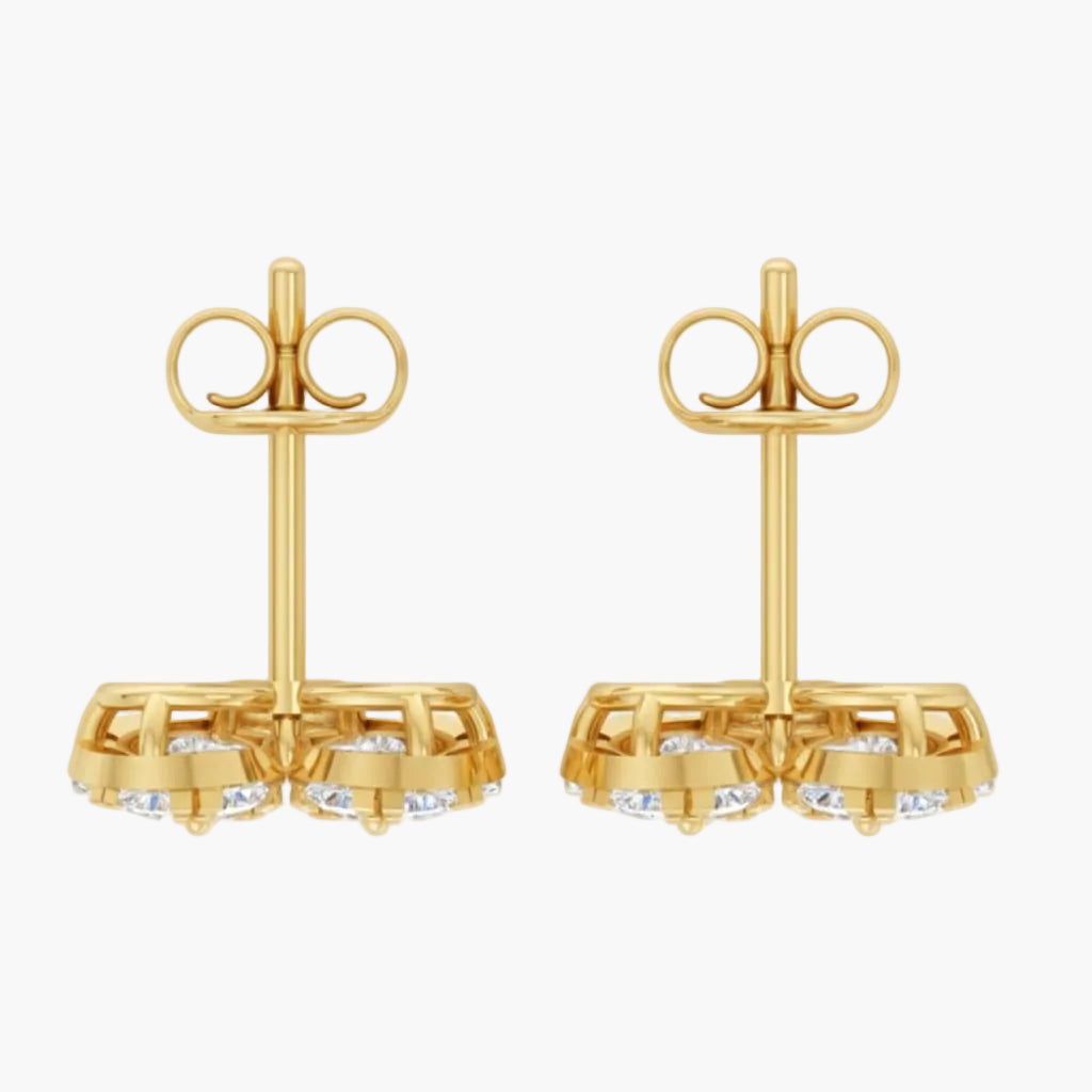 Pair of gold earrings with clear gemstones on a white background