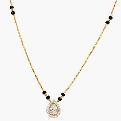 Gold necklace with a teardrop-shaped pendant and black beads on a white background