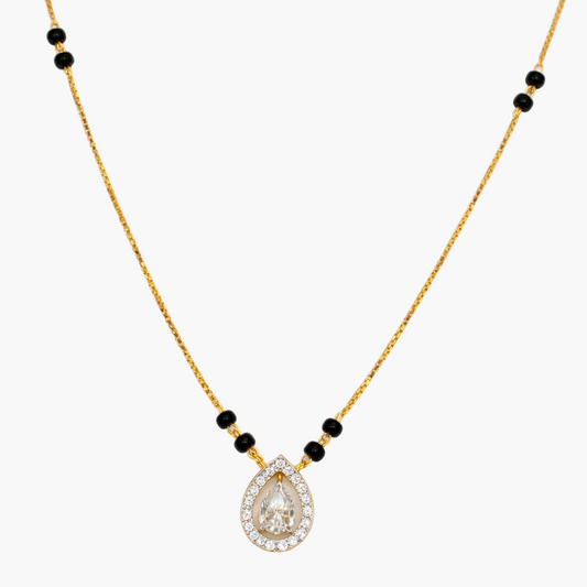 Gold necklace with a teardrop-shaped pendant and black beads on a white background