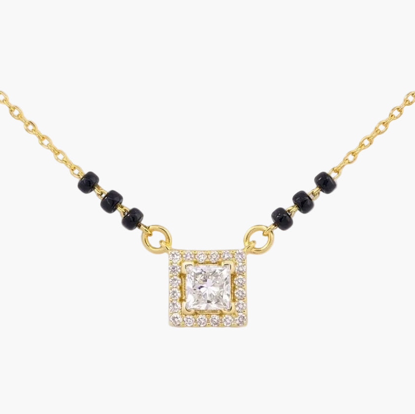 Gold necklace with a square diamond pendant on a white background