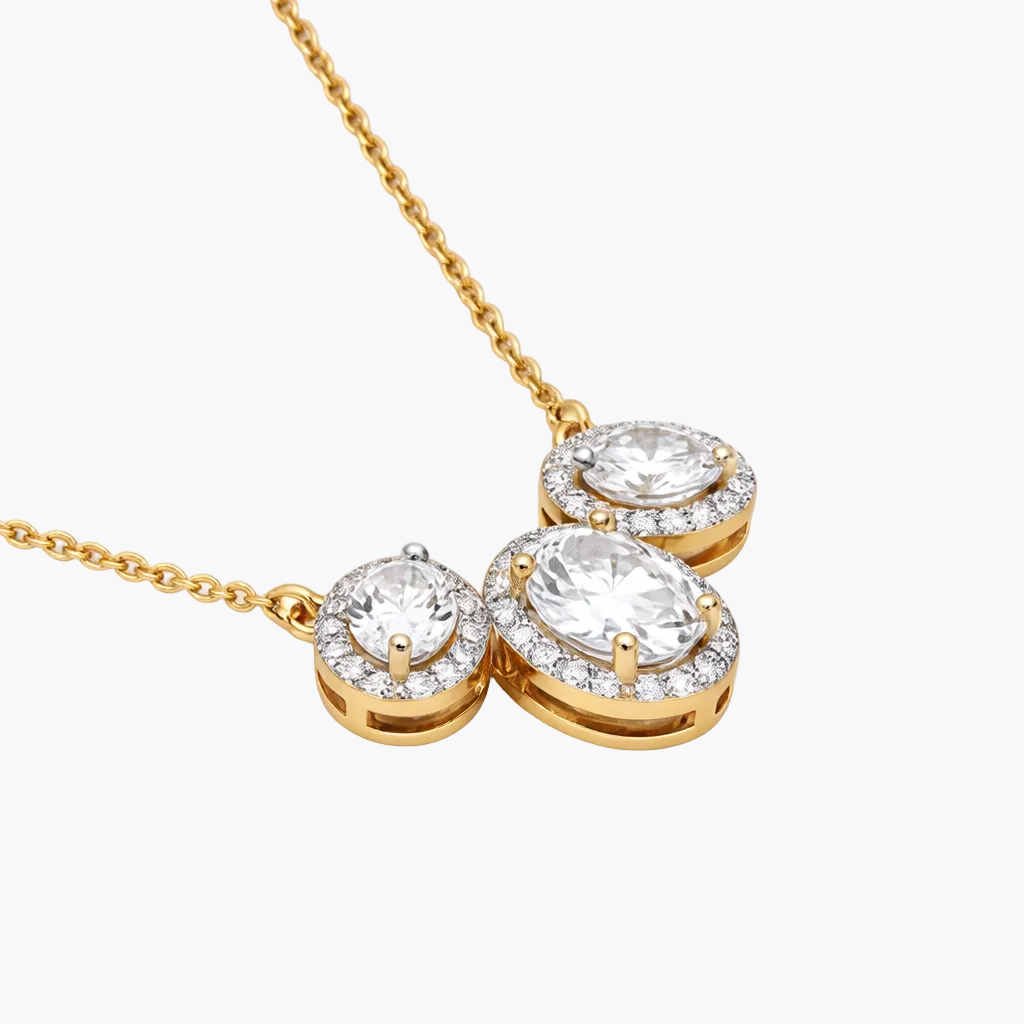 Gold necklace with three round diamond pendants on a white background