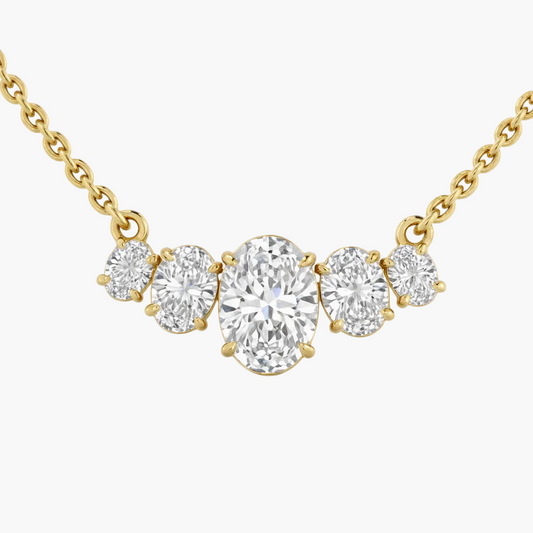 Gold necklace with oval and round diamonds on a white background