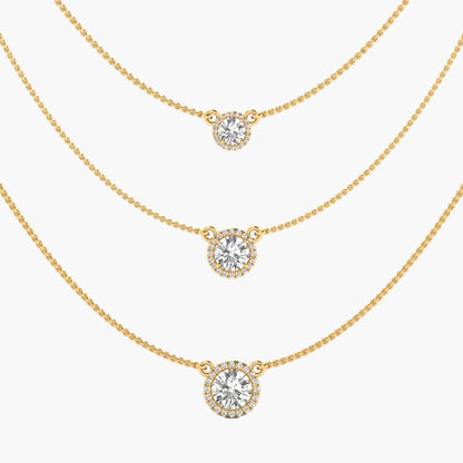 Three gold necklaces with round diamond pendants on a white background