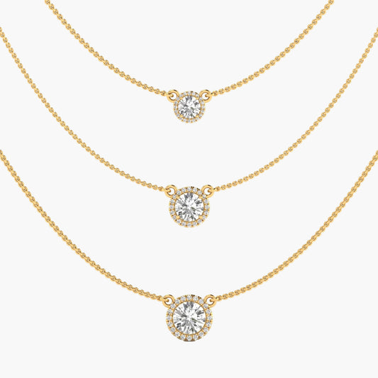 Three gold necklaces with round diamond pendants on a white background