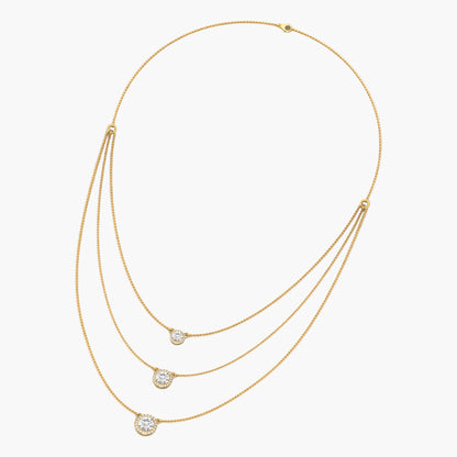 Gold necklace with three diamond pendants on a white background